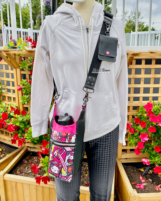 Mannequin wearing a white hoodie with a colorful "Bow Kitty" water bottle carrier in an outdoor setting with flowers and wooden lattice.