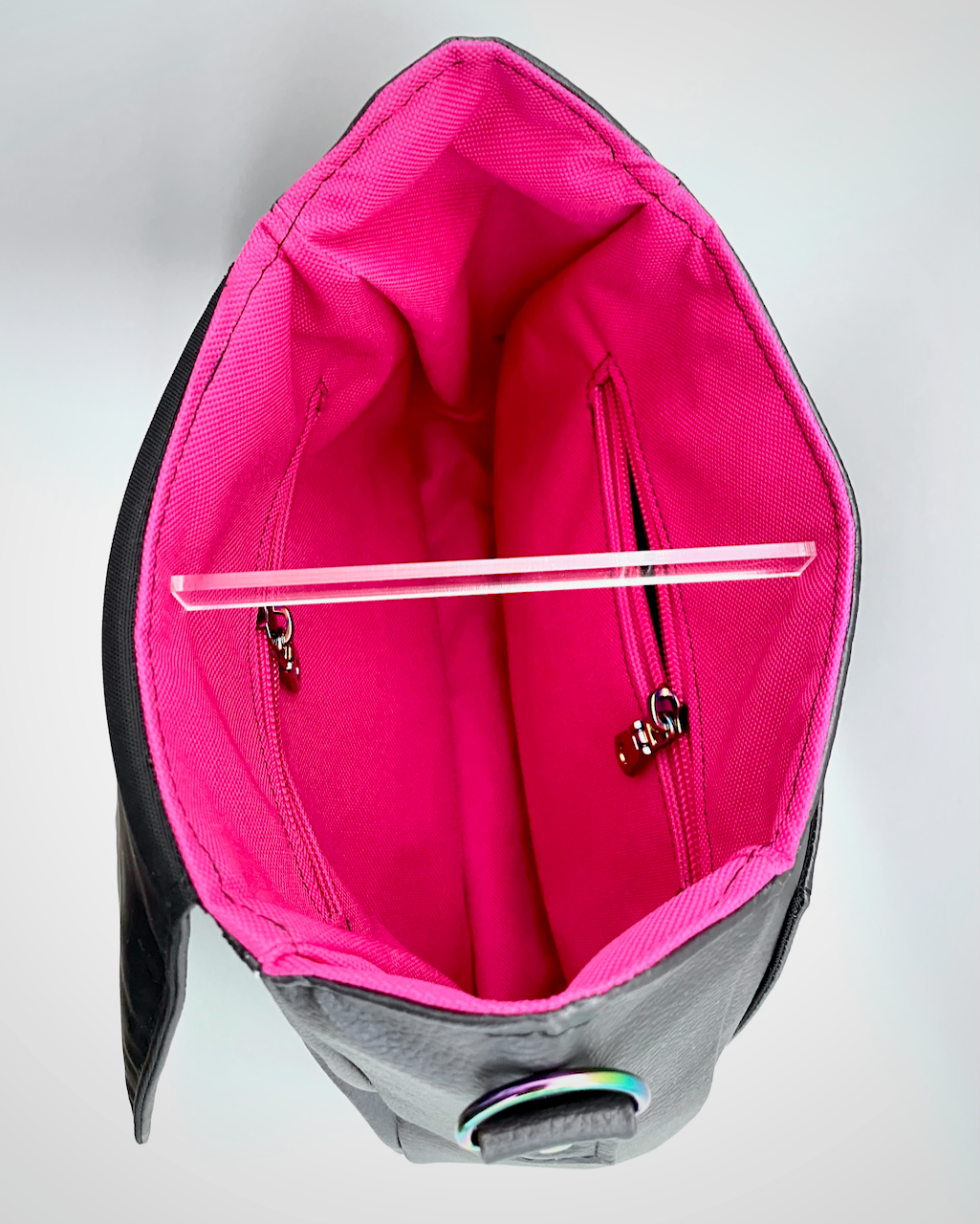 Gray bag with pink interior with two zipper pockets on a light gray background