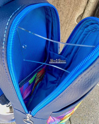 Interior view from above of a navy sling bag, with interior detail of blue lining and floral print slip pocket.