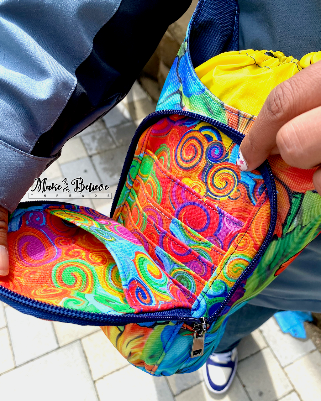 Colorful  swirled interior of a water bottle carrier, held open to show two slip pockets and 4 credit card slots.