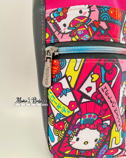 Close-up view of the "Bow Kitty" ripstop fabric, a  zipper pull that reads 'handmade', and rainbow coloured stitching