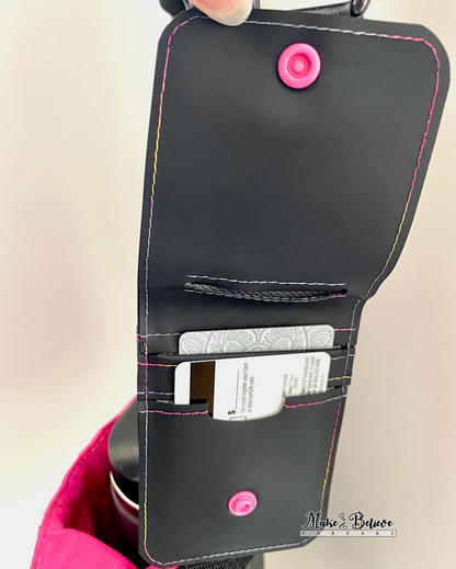 Opened black jelly vinyl wallet with pink snap and rainbow stitching holding 2 credit cards in slots on a neutral background