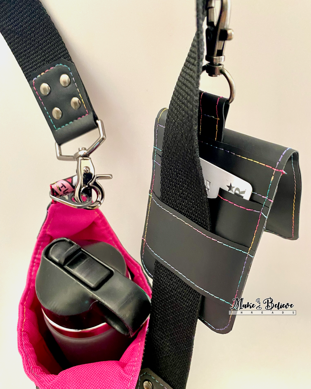 Back of a black jelly vinyl wallet with one card inserted into a slot, attached to a black strap with gunmetal hardware on a neutral background