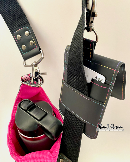 Back of a black jelly vinyl wallet with one card inserted into a slot, attached to a black strap with gunmetal hardware on a neutral background