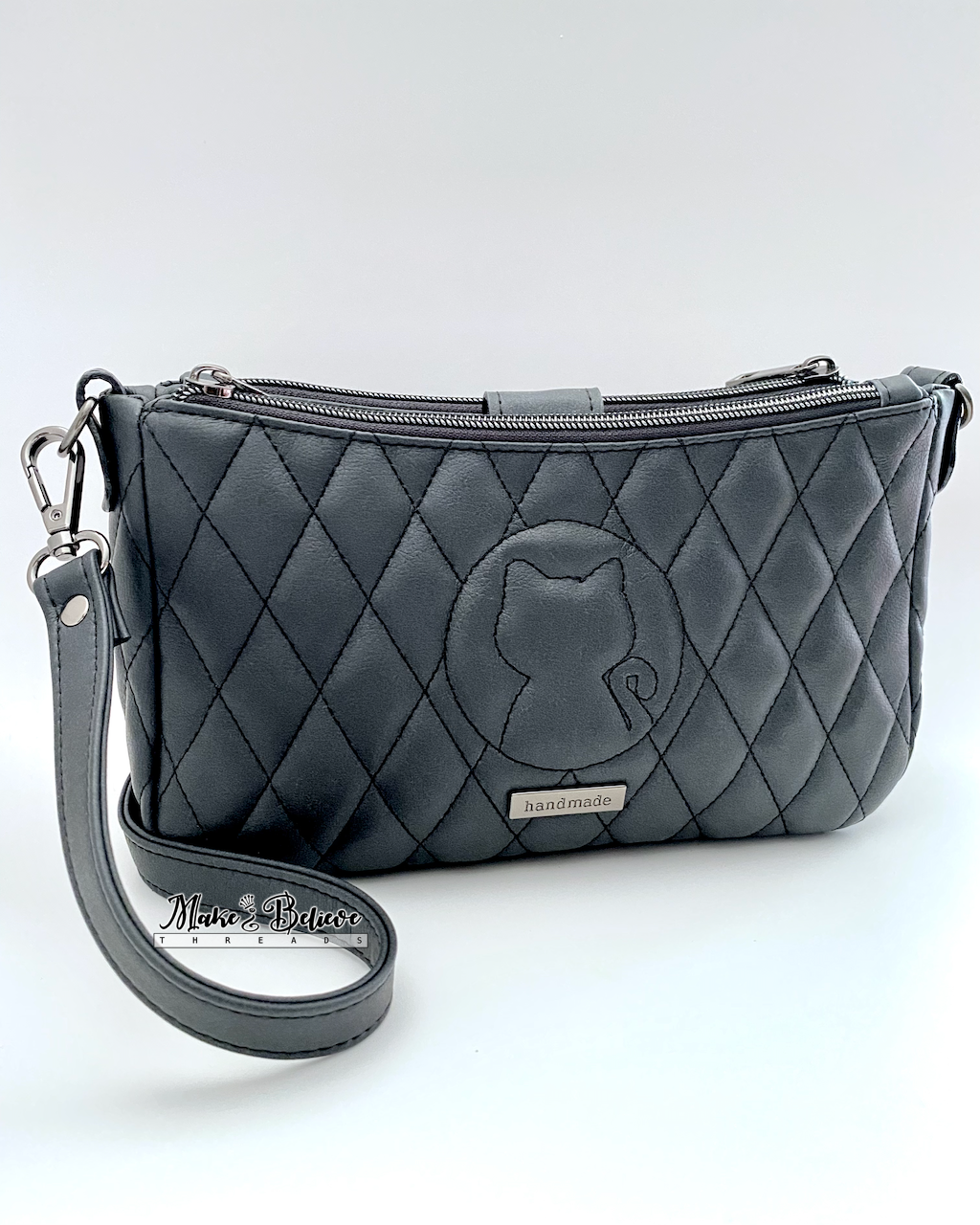 Quilted charcoal black shoulder bag with a quilted cat silhouette on a white background