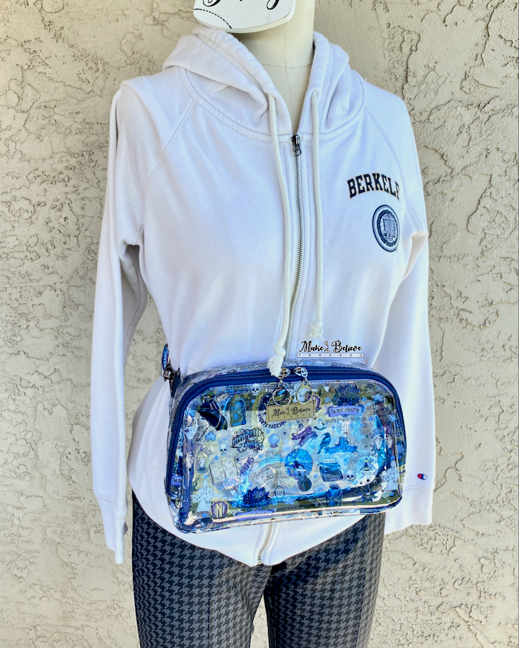 Mannequin with a transparent pack with blue accents and a Wednesday icons worn around the hip, photographed on a neutral background.