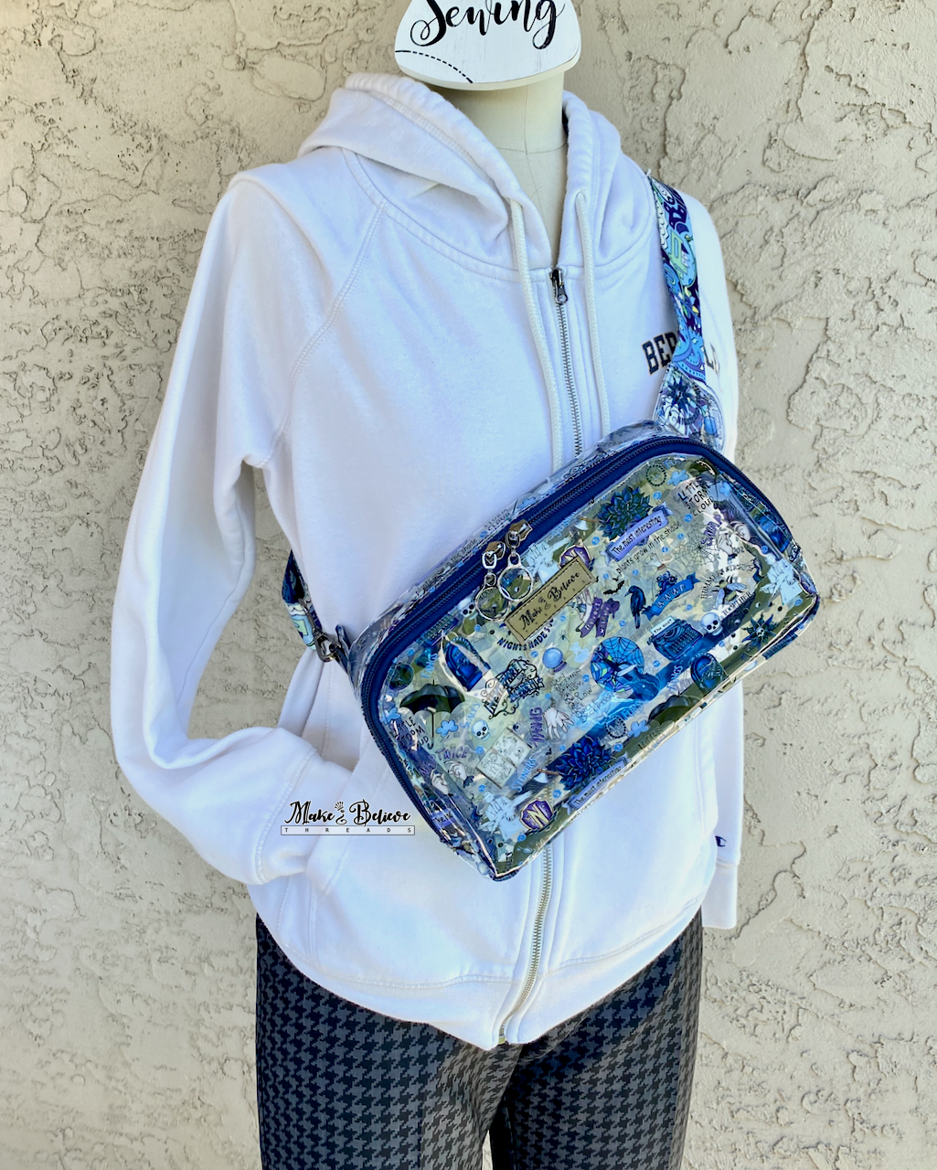 Mannequin with a transparent pack with blue accents and a Wednesday icons worn across the chest, photographed on a neutral background.