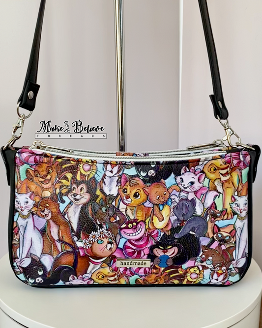 Colorful cartoon cats shoulder bag with nickel hardware on a white background