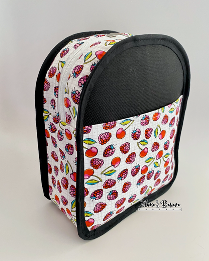 Inside out view of a small sling bag  with colorful fruit-patterned fabric and black binding on a white background