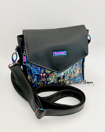 Black crossbody bag with rainbow hardware on the flap and space wars  droids printed vinyl on the front