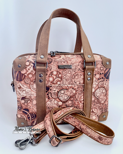 Language-patterned handbag with brown accents and shaped like an steam trunk on a light gray background