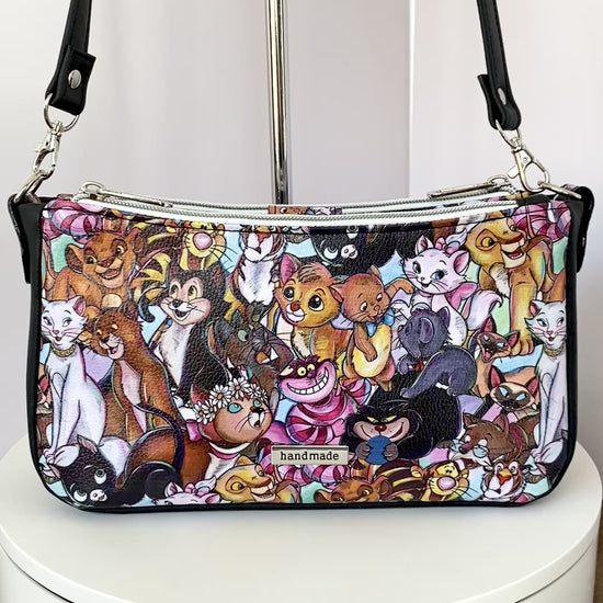 Video of a cartoon cat shoulder bag as it rotates on a turntable, showing all four sides.
